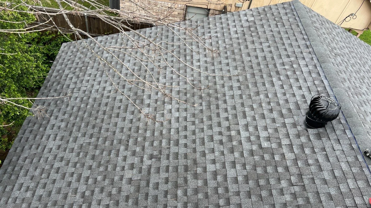 Gray architectural shingles with a black turbine vent